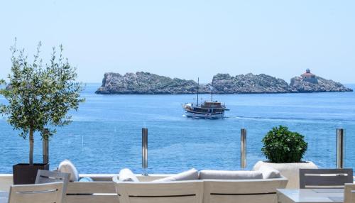 a boat in the water with a table and chairs at Royal Ariston Hotel in Dubrovnik