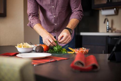 a man preparing food on a counter in a kitchen at Candlewood Suites Austin-Round Rock by IHG in Round Rock