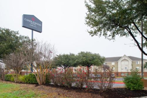 a sign in front of a building with flowers at Candlewood Suites Austin-Round Rock by IHG in Round Rock
