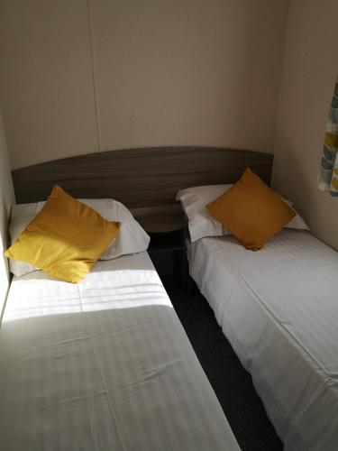 two beds sitting next to each other in a room at lakeland leisure park in Flookburgh