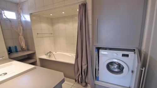une salle de bain avec une machine à laver et un lavabo dans l'établissement Miremer, à Sainte-Maxime