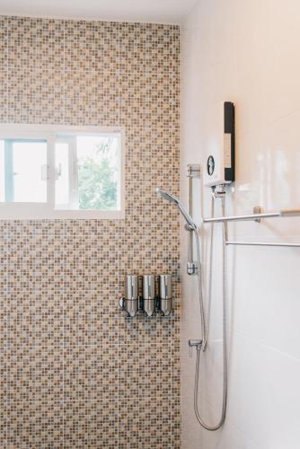 a bathroom with a shower with a window and a sink at So Good Haad Rin Resort in Haad Rin