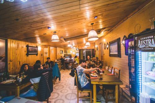 a group of people sitting at tables in a restaurant at Hostal Alcázar in Puerto Natales