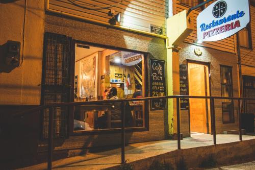 a store front of a restaurant with a window at Hostal Alcázar in Puerto Natales
