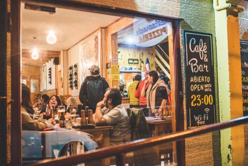 a group of people sitting at tables in a restaurant at Hostal Alcázar in Puerto Natales