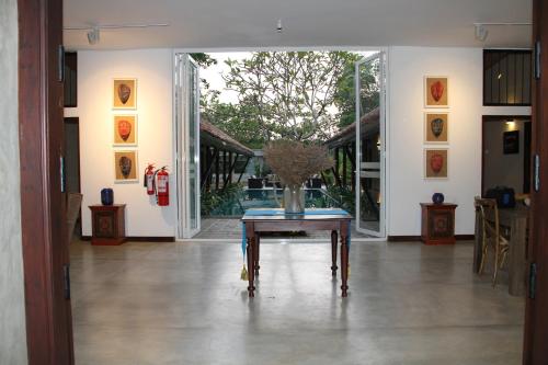 a room with a table with a vase on it at The Aluthgama House in Aluthgama