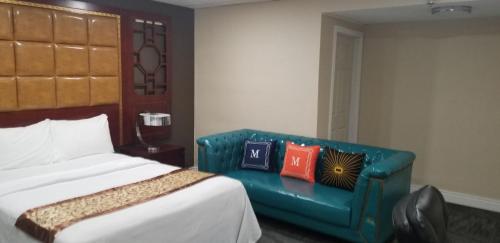 a bedroom with a bed and a blue couch at Baymont by Wyndham Montreal Airport in Dorval