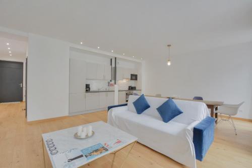 un salon avec un canapé blanc et une table dans l'établissement L'Essentiel de Stanislas, à Nancy