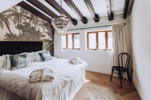 una camera con un grande letto e un lampadario a braccio di Ocho Suites & Kitchen a Palma de Mallorca