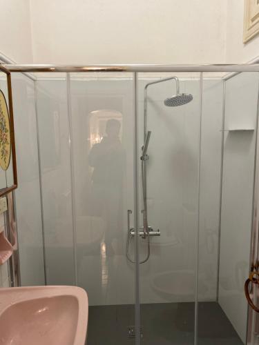 W łazience znajduje się szklana kabina prysznicowa i umywalka. w obiekcie Villino Caproni w Viareggio