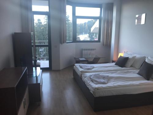 ein Schlafzimmer mit einem großen Bett und zwei Fenstern in der Unterkunft Flora Apartment 619 in Borowez