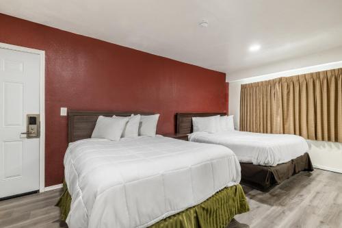 2 camas en una habitación de hotel con paredes rojas en Econo Lodge, en Needles
