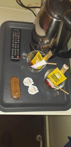 a table with a tray with food and a remote control at hotel Melissa in Péruwelz