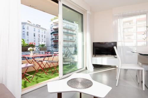 un salon avec une grande fenêtre et une table dans l'établissement MARRIOTT : 2 BEDS/2 BATHS SEA VIEW, à Cannes