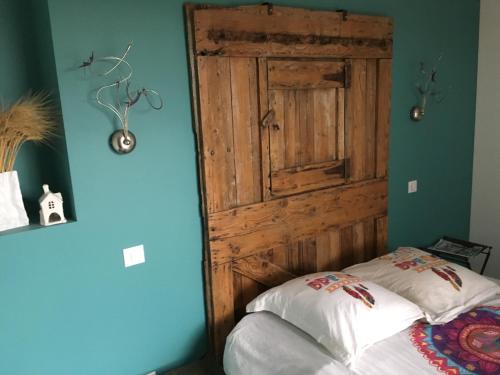 um quarto com uma porta de madeira e uma cama em Gîte PLACE FOR YOU em Malissard