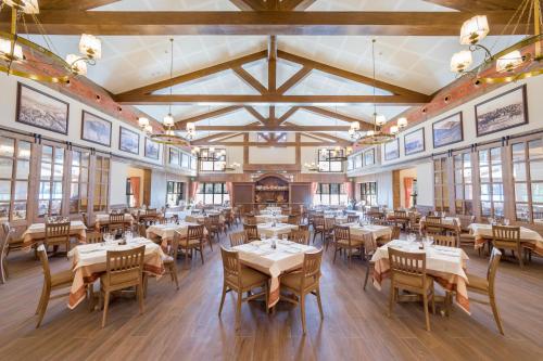a dining room with tables and chairs and windows at PortAventura Hotel Colorado Creek - Includes PortAventura Park Tickets in Salou