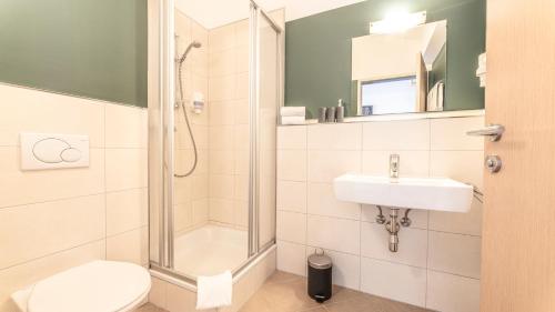 ein Bad mit einer Dusche, einem WC und einem Waschbecken in der Unterkunft Appartement Berge in Sankt Anton am Arlberg