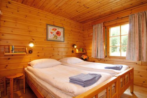 1 dormitorio con 1 cama en una cabaña de madera en Hapimag Ferienwohnungen Punkaharju, en Punkaharju