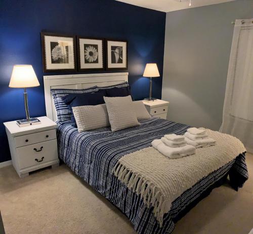 a bedroom with a bed with blue walls and two lamps at Terra Verde Vacation Rentals in Kissimmee