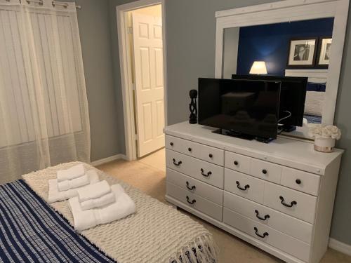 a bedroom with a white dresser with a television on it at Terra Verde Vacation Rentals in Kissimmee