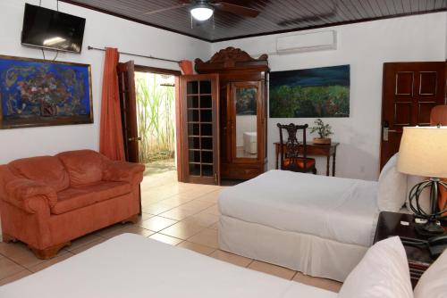 a bedroom with a bed and a couch and a chair at La Posada del Arcangel in Managua