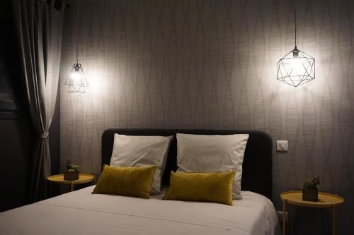 a bedroom with a bed with two tables and two lights at Les Cépages in Le Mesnil-sur-Oger
