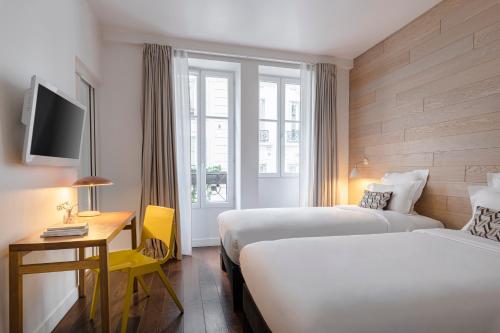 a hotel room with two beds and a window at 9Hotel Opera in Paris