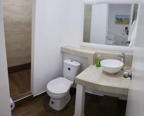 a bathroom with a white toilet and a sink at Coral House San Andres in San Andrés