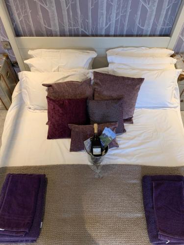 a large bed with pillows and a candle on it at The Stowe in Shrewsbury