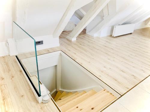 a glass staircase in a white room with wood floors at Apartamenty VIP in Ustka