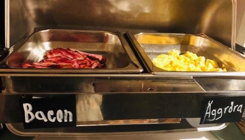 two trays of bacon and scrambled eggs in a buffet at Lages Motel in Borås