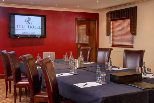 a conference room with a long table with chairs and a television at The Bull Hotel; Sure Hotel Collection by Best Western in Peterborough
