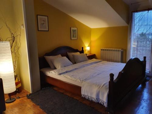 a bedroom with a large bed with yellow walls at Aerport - Natura Apartment in Belgrade