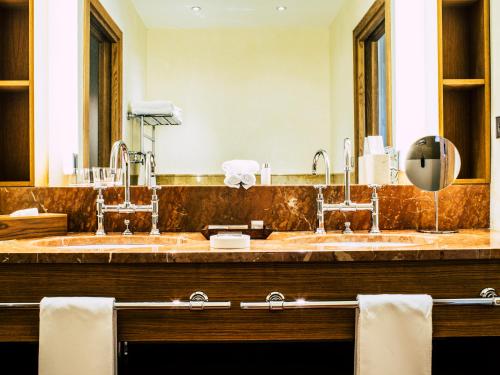 a bathroom with two sinks and a large mirror at Abadia Retuerta LeDomaine in Sardoncillo