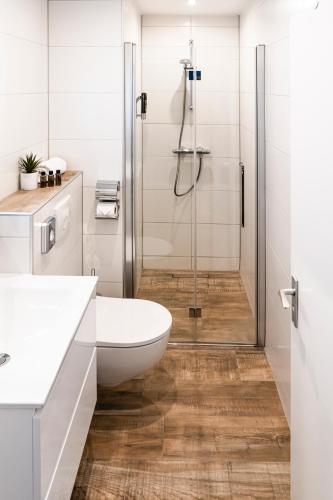 a bathroom with a shower with a toilet and a sink at Hotel Brasserie de Huifkar in Middelburg