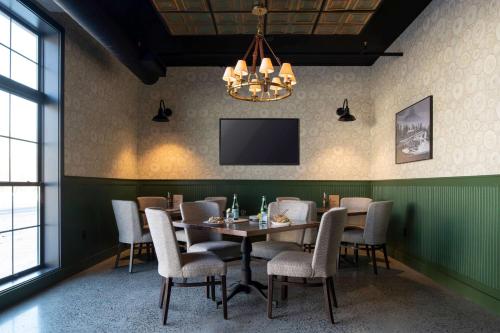 a dining room with a table and chairs and a tv at Cantilever Hotel, Trademark Collection by Wyndham in Ranier