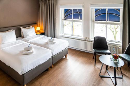 a hotel room with a bed and a chair at Hotel Brasserie de Huifkar in Middelburg