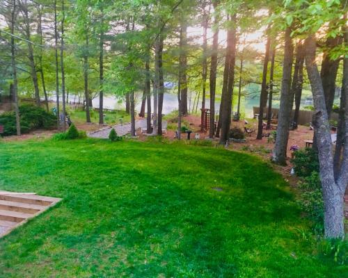 a park with trees and green grass and benches at Clear Pond Getaway in Plymouth