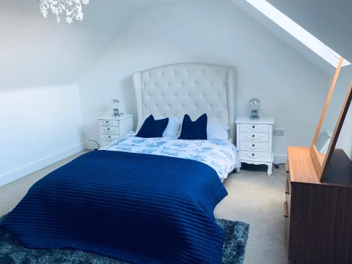 ein Schlafzimmer mit einem großen Bett mit blauer Bettwäsche und blauen Kissen in der Unterkunft Holiday Home Epworth in Epworth