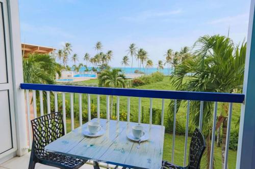 einen Tisch und Stühle auf einem Balkon mit Meerblick in der Unterkunft AZUR - Séjour FARNIENTE en Guadeloupe! in Le Gosier