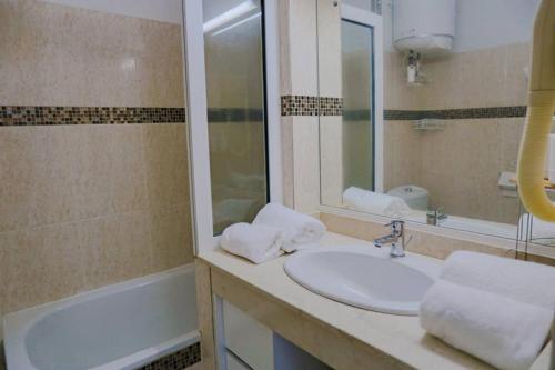 ein Badezimmer mit einem Waschbecken, einem Spiegel und einer Badewanne in der Unterkunft AZUR - Séjour FARNIENTE en Guadeloupe! in Le Gosier