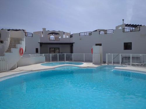 a large swimming pool in front of a building at Aqua Apt Sunrise & Sea Views in Costa Teguise