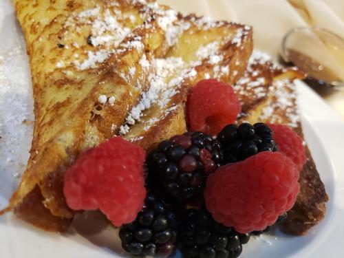 a plate of food with french toast and berries at Omni Severin Hotel in Indianapolis