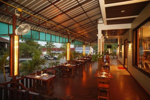 a restaurant with tables and chairs in a building at Boon Siam Hotel in Krabi town