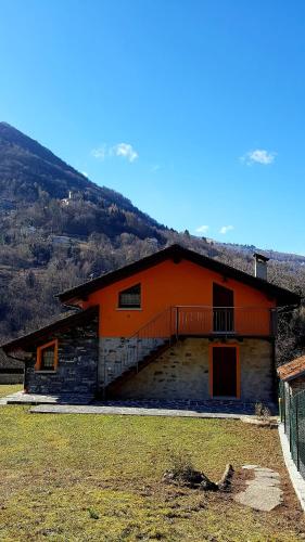 an orange building with a staircase in front of it at Baita Eleonora in Argegno