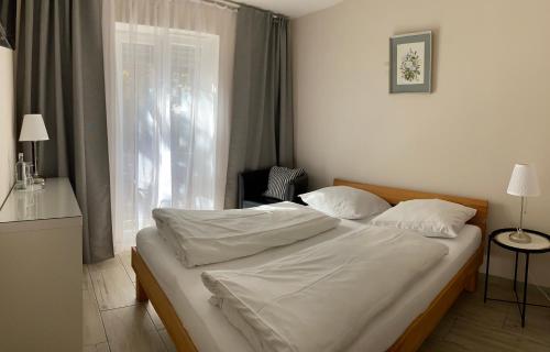 a bedroom with a bed with white sheets and a window at Arena Stadt München in Munich