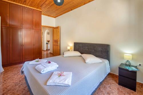 a bedroom with a bed with towels on it at Villa RAXI in Plátanos