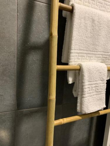 a towel rack with white towels in a bathroom at BUS STATION Suites & Studios in Coimbra