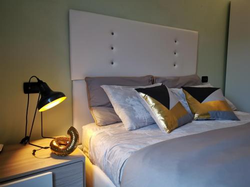 a bedroom with a bed with pillows and a lamp at LuxOry Center - Brescia centro in Brescia