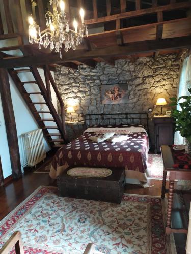 1 dormitorio con cama y pared de piedra en Posada de Pedreña, en Pedreña
